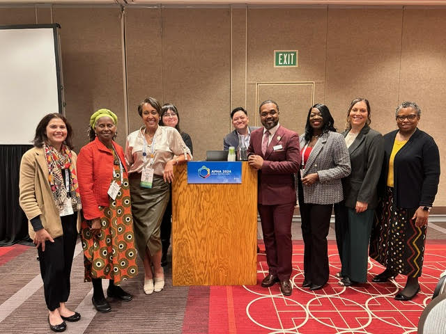 A group of speakers and participants posing together at the APHA Annual Meeting workshop.