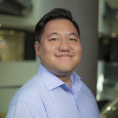 a person with dark hair and a blue dress shirt